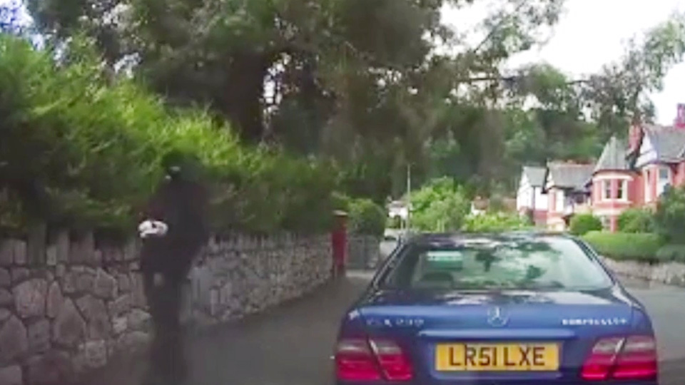 Watch as balaclava-clad thief caught out by parked car's dashcam